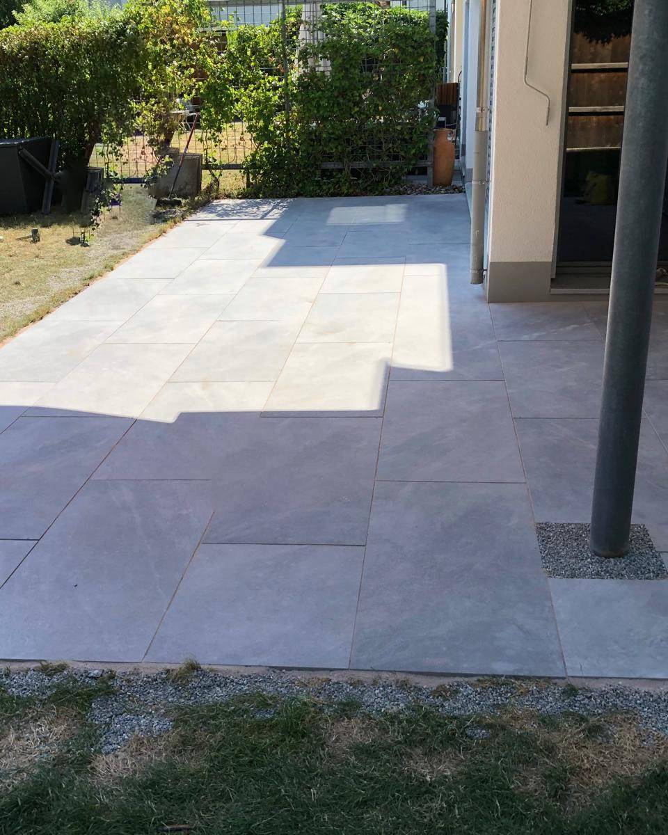 Terrasse en dalles poses sur pelouse ensoleillee